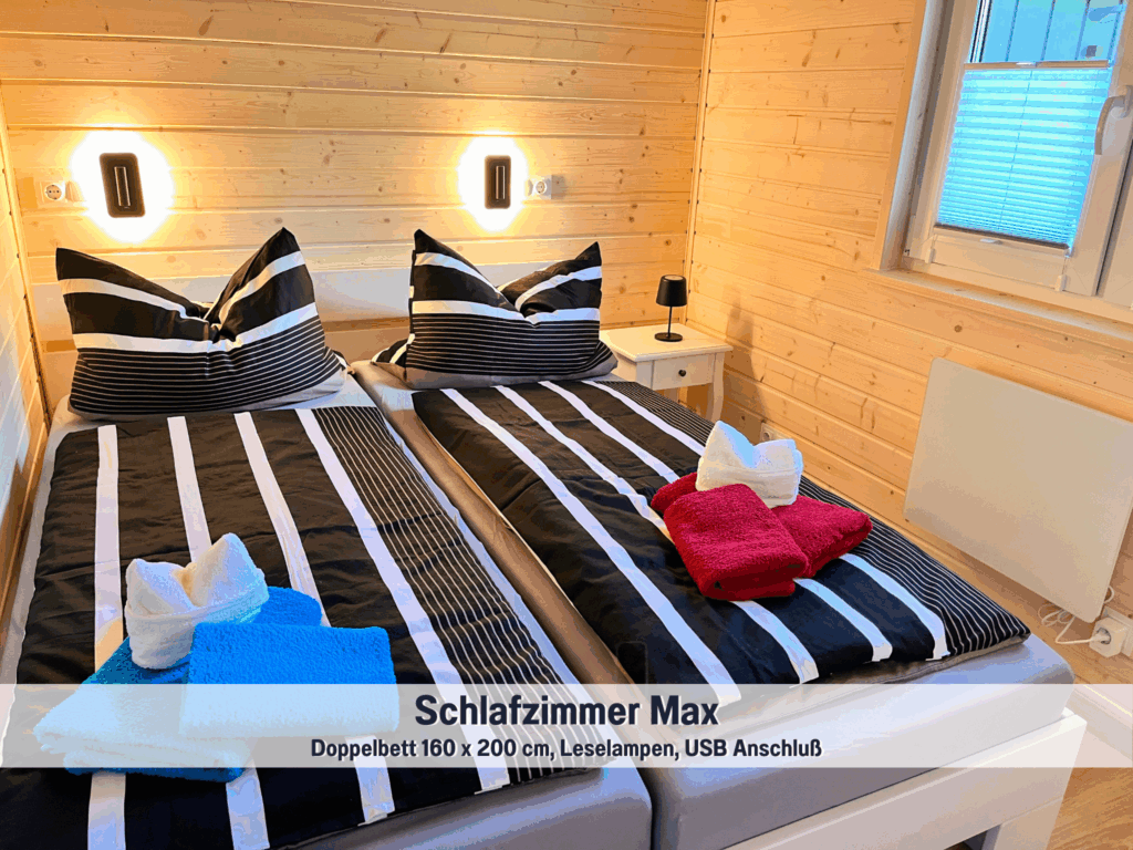 Gemütliches Schlafzimmer im Tiny House Max mit Doppelbett (160 × 200 cm), Leselampen und USB-Anschluss – moderner Rückzugsort im Wohlfühlparadies Max & Moritz, Bad Stuer an der Mecklenburgischen Seenplatte.