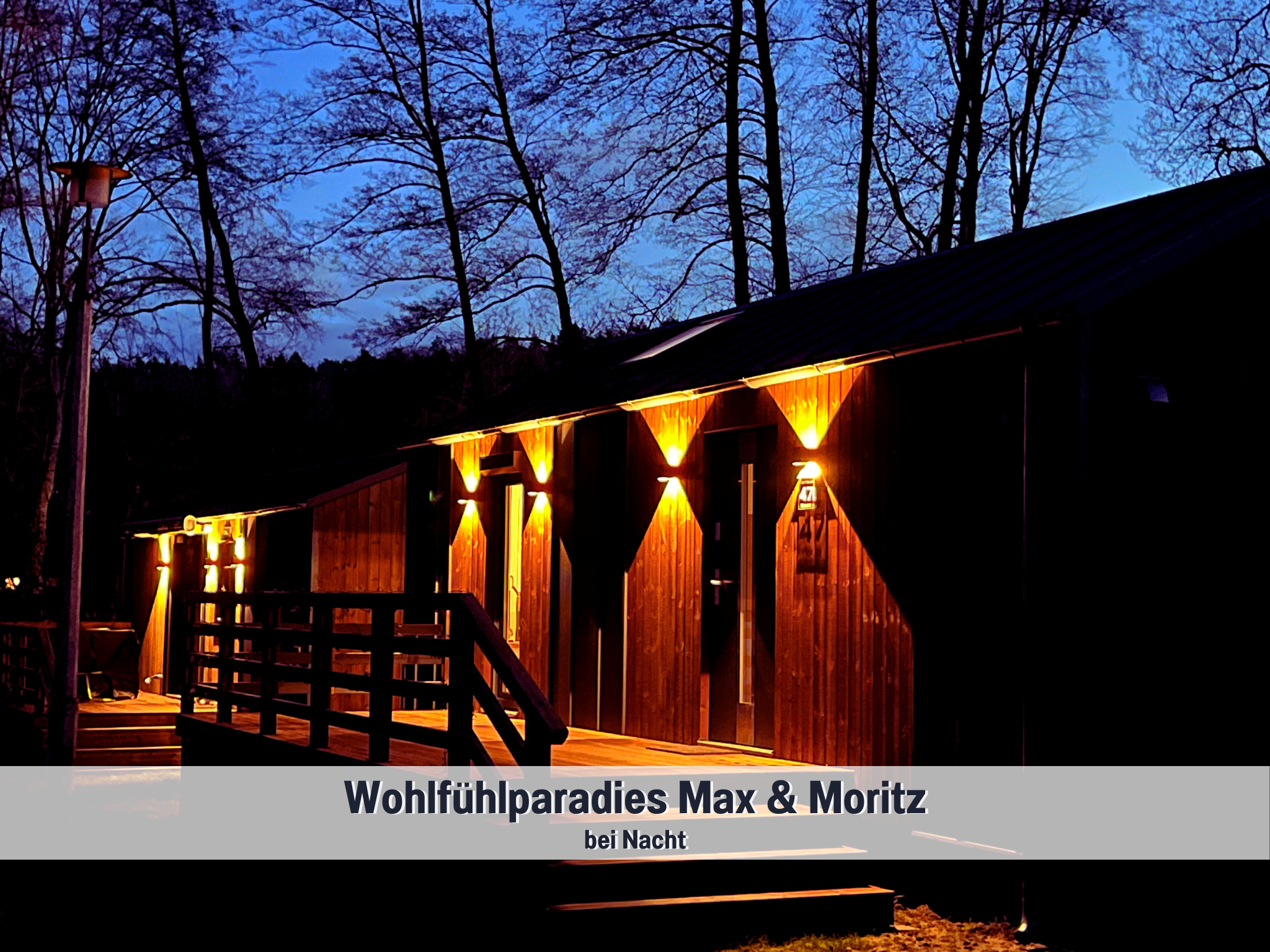 Wohlfühlparadies Max & Moritz bei Nacht mit stimmungsvoller Außenbeleuchtung – Tiny Houses in harmonischer Waldlage am Plauer See, perfekt für ruhige Abende zu zweit.